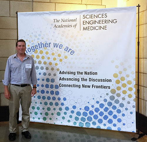 Man standing in front of National Academies of Sciences banner.