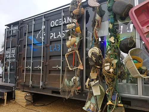 An old boxcar with trash displayed on it.