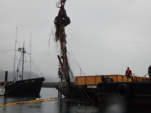 Removal of part of a sunken vessel and derelict nets from water.