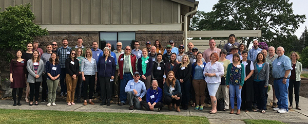 Large group of people posing outdoors for a photo.