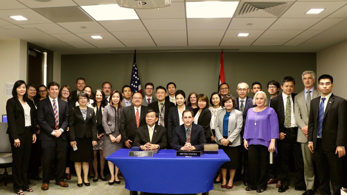 Large group poses for picture in front of a table.