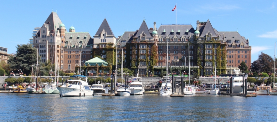 Boats in a harbor with buildings in background.