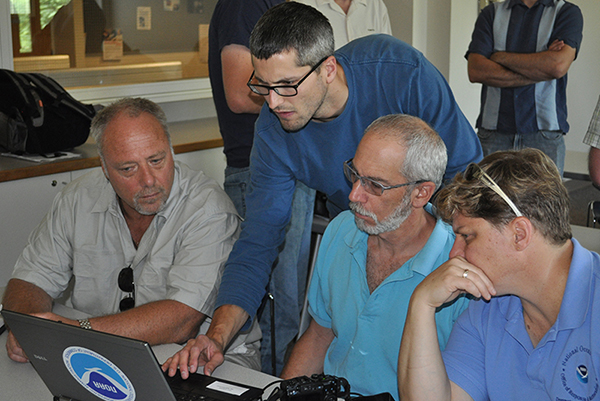 Four people looking at a computer. 