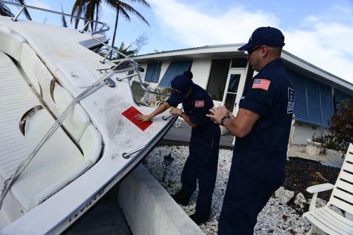 Woman placing a red tag on a vessel.