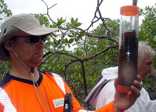 Man holding a sample in a clear container.