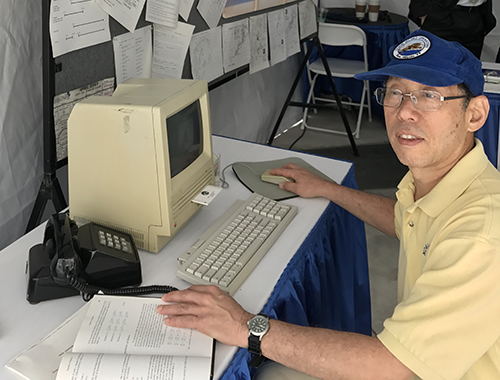 Man sitting at 1980s computer station.