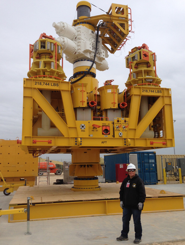 Woman in front of large piece of industrial equipment.