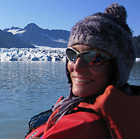 Woman in sunglasses, with water and ice in background.