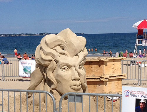 Sand sculpture of a head on the beach.