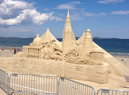 Sand sculpture of a castle on the beach.