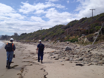 Two men walking along the beach.