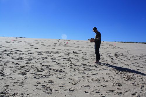 Man standing alone on a beach.