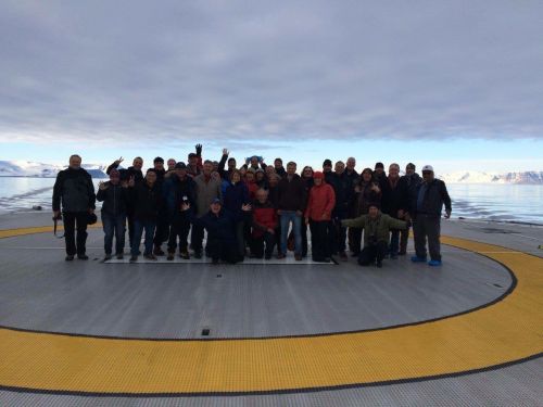 Group of people standing on a helicopter pad. 