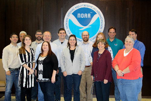 Group of people in front of a NOAA logo.