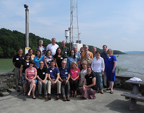 Group of adults posing near water.