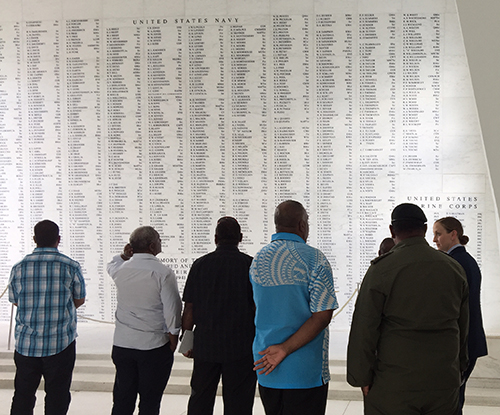 Group stands looking at a wall of names.