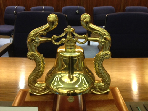 Brass bell on a wood desk.