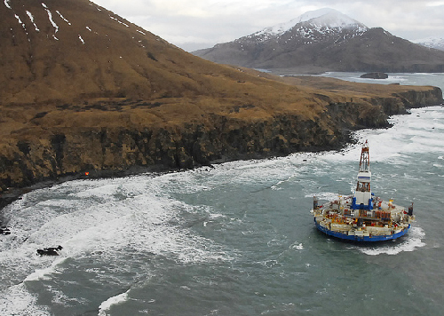 A drilling rig floating near an island.
