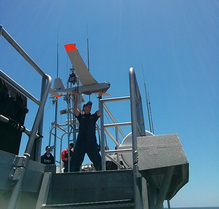 Man launching UAS from ship.