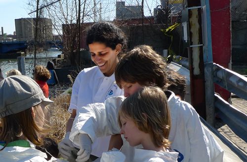 Photo of woman with children next to a canal. 