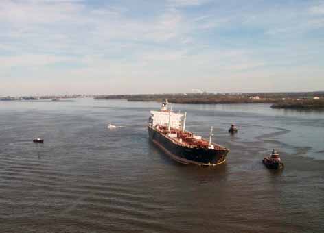 Ship Athos I on the Delaware River with response boats nearby.