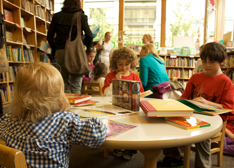 Kids reading books in a book store.