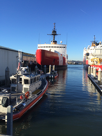 The U.S. Coast Guard icebreaker, Healy, in port with tugs and other ships.