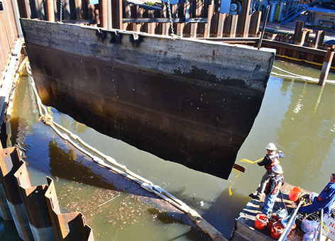 A piece of the vessel Davy Crockett is lifted out of the water during salvage.