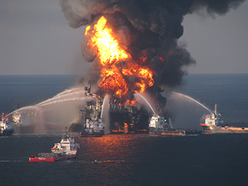 Burning Deepwater Horizon rig with firefighting ships in the Gulf of Mexico.