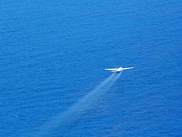 Airplane sprays dispersants over an oil slick in the Gulf of Mexico.