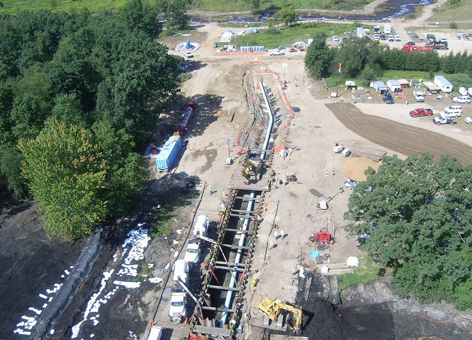 Pipeline dug up for an oil spill cleanup next to a creek.