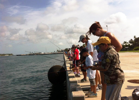 Families fishing off of a seawall.