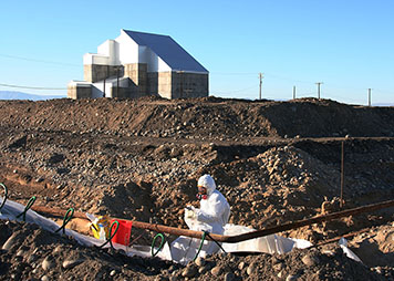 A worker drains a pipe that contains liquid chromium next to a nuclear reactor.