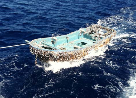 The 20-by-6-foot skiff covered in barnacles is towed behind a fishing vessel.