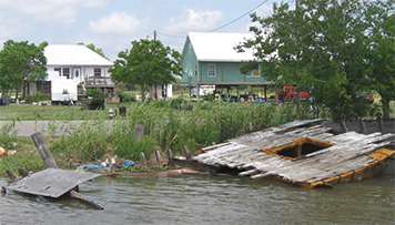 Destroyed dock and debris along a populated canal in Louisiana.