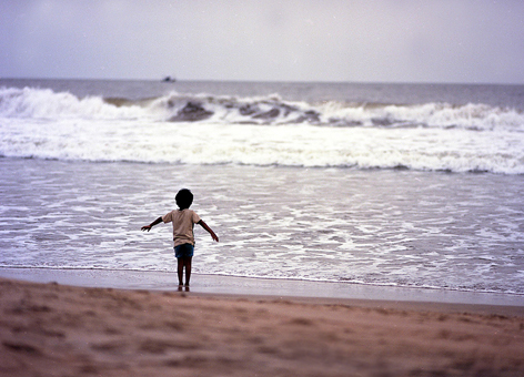 Boy running on beach.
