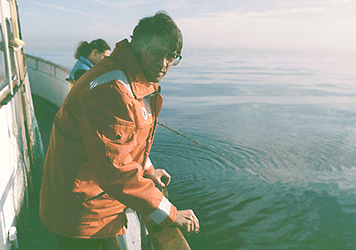 John Robinson leaning on the edge of a boat.