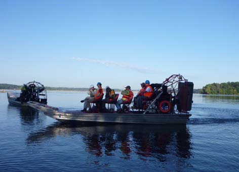 A scientific team monitors cleanup progress in an airboat on the Kalamazoo River