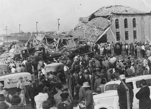 Crowds of people and emergency vehicles surrounding damaged school.