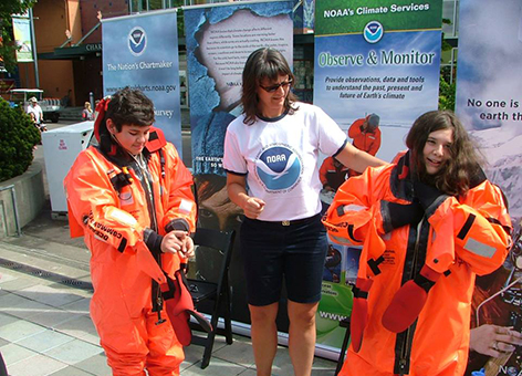 Kids trying on survival suits at the NOAA booth at Seattle Science EXPO Day.