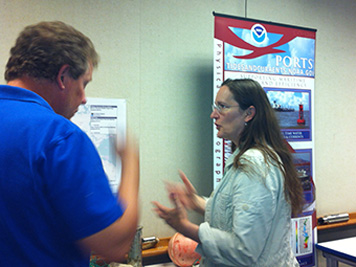 NOAA employee discussing marine debris with a woman at NOAA Open House.