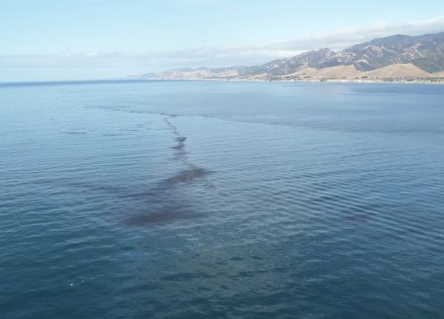 A view of an oil streak visible on the ocean surface near the coast.