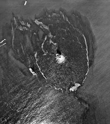 Aerial view of oil platform and response ships, surrounded by oil slicks.