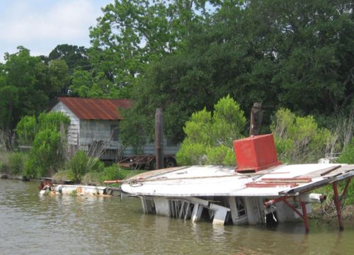 Sunken boat next to a house in Louisiana.
