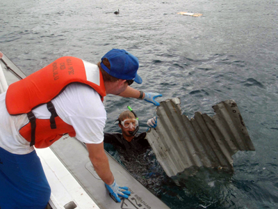 Photo: A diver retrieves a piece of debris from the 2011 Japan tsunami.
