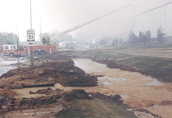 Melted butter in dug-out channels next to a road and fire truck.