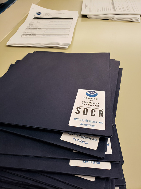 A stack of folders prepped with materials for SOCR students. Photo credit: NOAA