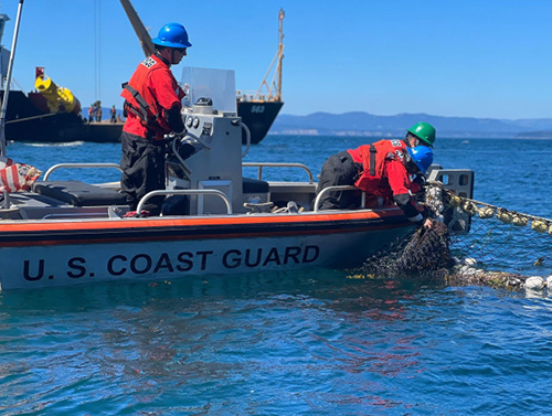 A U.S. Coast Guard team removing the floating fishing nets from the fishing vessel Aleutian Isle on August 24, 2022. Image credit: U.S. Coast Guard