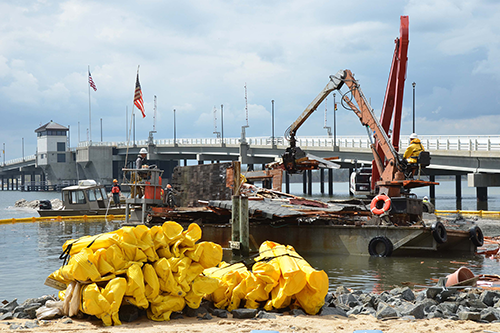 Marine debris caused by demolition of a home destroyed by Hurricane Sandy being removed from entering further into Barnegat Bay (Photo: Federal Emergency Management Agency).