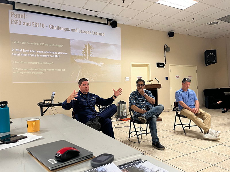 Two NOAA staff and one U.S. Coast Guard staff give a panel presentation to a classroom.
